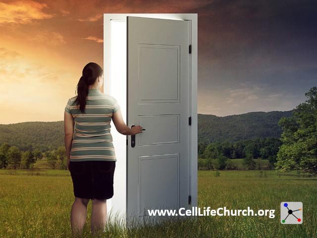 Woman standing in front of a door in an open field.